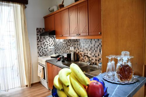 a kitchen with a bunch of bananas and apples on a counter at Sitos Home in Sparti