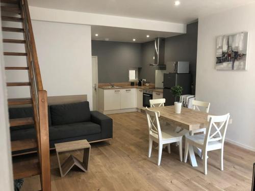 a living room with a table and a couch at Appartement Duplex 8 personnes proche télécabines in Ax-les-Thermes