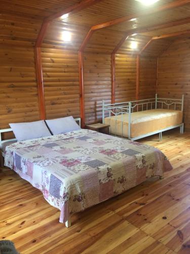 チェルカースィにあるДомик для отдыха рядом Днепрの木造キャビン内のベッドルーム1室(ベッド2台付)