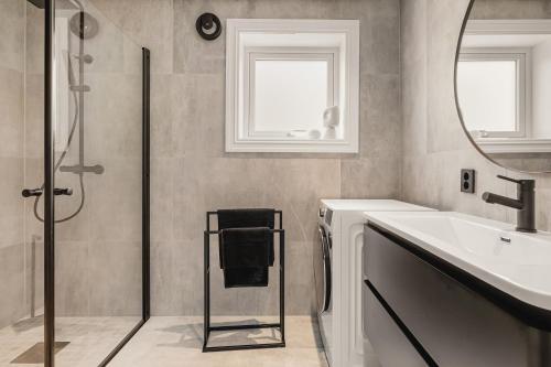 a bathroom with a shower and a sink and a mirror at Odda View in Odda