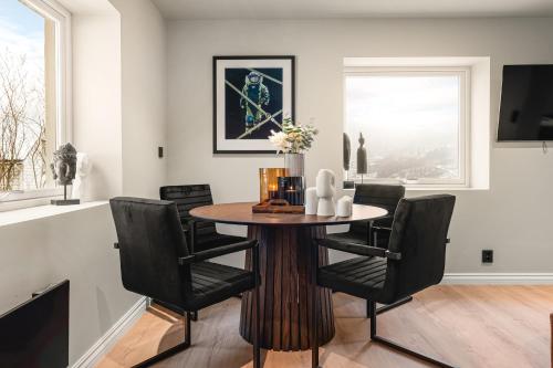 a dining room with a wooden table and black chairs at Odda View in Odda