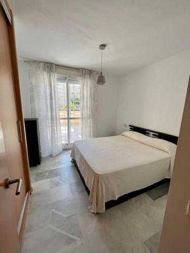 1 dormitorio con cama y ventana grande en Marina Serena Golf 1ª linea Playa, en Roquetas de Mar