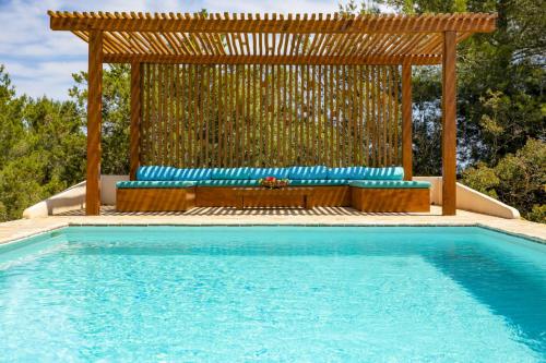 una piscina con pérgola de madera y un banco junto a una piscina en Can Lorenzo, en Sant Llorenç de Balàfia