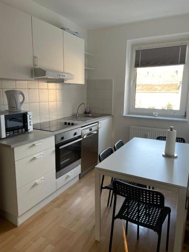 a kitchen with a table and a table and chairs at - SANO Apartments - DGR - Hagen Zentral - Free Parking - WIFI - Washing Machine in Hagen