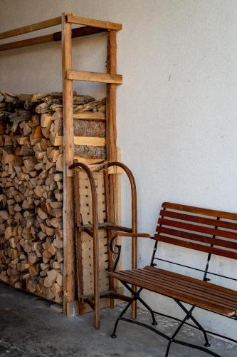 a bench sitting next to a pile of fire wood at Bodensee Apartments, Sauna, Lake Walks, Free Parking, Self Checkin, Nature Reserve, Restaurants Nearby in Gaißau
