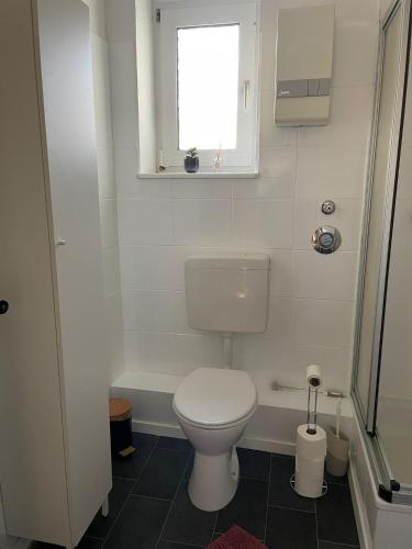 a small bathroom with a toilet and a window at - SANO Apartments - DGR - Hagen Zentral - Free Parking - WIFI - Washing Machine in Hagen