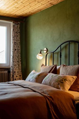 a bedroom with a bed with green walls and a lamp at Bodensee Apartments, Sauna, Lake Walks, Free Parking, Self Checkin, Nature Reserve, Restaurants Nearby in Gaißau