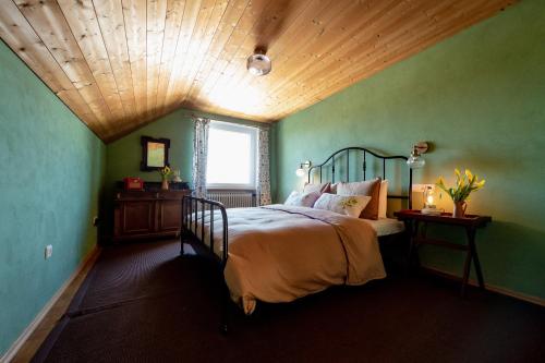 a bedroom with a bed with green walls and a wooden ceiling at Bodensee Apartments, Sauna, Lake Walks, Free Parking, Self Checkin, Nature Reserve, Restaurants Nearby in Gaißau
