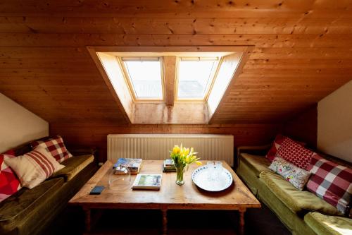 a room with a table and two couches and a window at Bodensee Apartments, Sauna, Lake Walks, Free Parking, Self Checkin, Nature Reserve, Restaurants Nearby in Gaißau