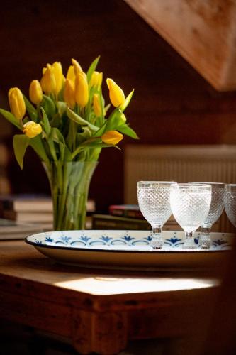 a plate with a vase of yellow flowers on a table at Bodensee Apartments, Sauna, Lake Walks, Free Parking, Self Checkin, Nature Reserve, Restaurants Nearby in Gaißau