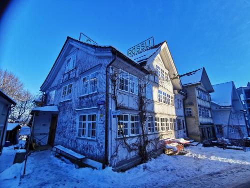 um edifício com um sinal na neve em Gasthaus Rössli em Trogen
