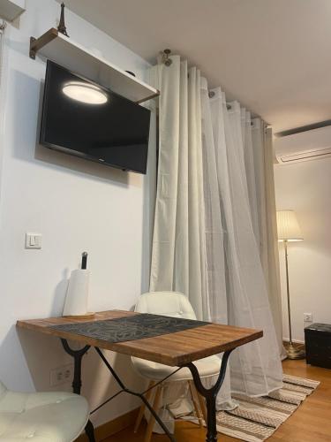 a table and chairs in a room with a curtain at Studio Centre Ville in Nice