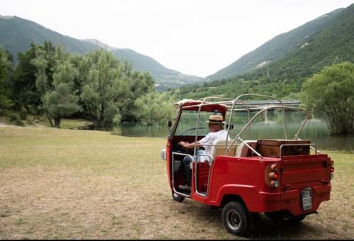a man driving a red jeep in a field at A casa di Rocco in Castel di Sangro