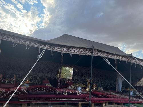 a large tent with red pillows under it at مخيم يمك دروبي in AlUla