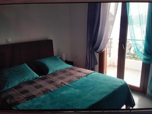 sypialnia z łóżkiem i dużym oknem w obiekcie Irineos apartment's w mieście Patmos
