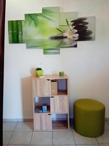 stół i zielony stołek obok ściany w obiekcie Irineos apartment's w mieście Patmos