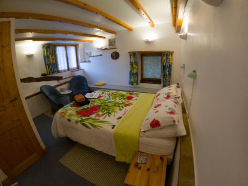 1 dormitorio con 1 cama y 1 silla en una habitación en Le Moulin du Chemin, en Scillé
