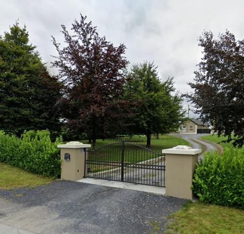 a gate in a driveway with a house at Horseleap BNB in Moate