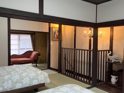een slaapkamer met een bed en een stoel bij 浪漫宿花町 in Mitarai