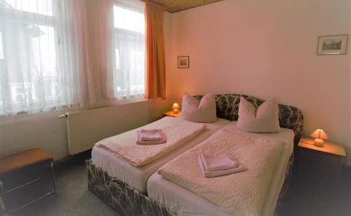 a bedroom with two beds with pink sheets at Hotel Zur Henne in Schmiedefeld am Rennsteig