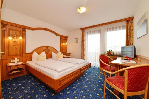 Habitación de hotel con cama, mesa y sillas en Hotel-Pension Seebad "Seegenuss-Natur-Spa", en Sulzberg