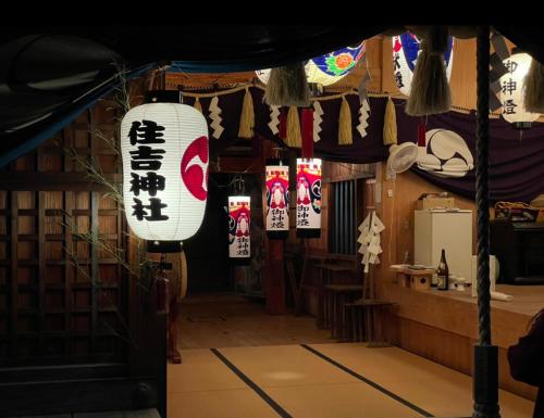 a restaurant with a lantern and signs in a room at 浪漫宿花町 in Mitarai