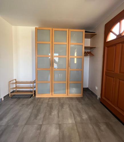 une pièce vide avec une porte en bois et des étagères en verre dans l'établissement Maison spacieuse avec grand jardin et parking à 20 min de Lyon, à Simandres