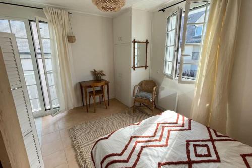 une chambre avec un lit, une table et des fenêtres dans l'établissement Studio dans le centre près de la mer, à Agon-Coutainville