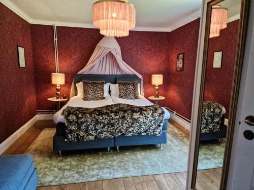 a bedroom with a bed and two lamps and a mirror at Alstrums gård in Killstad