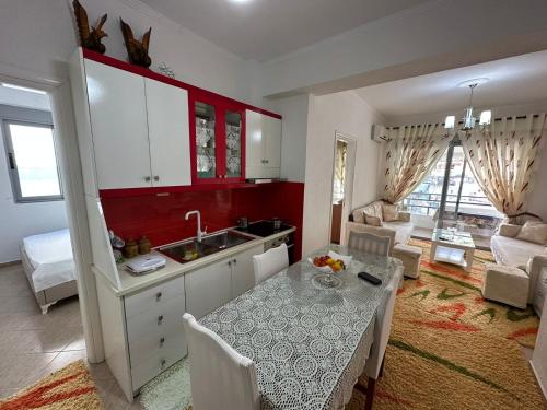 cocina y sala de estar con mesa y fregadero en Taulant, en Sarandë