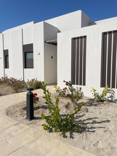 a white house with flowers in front of it at Hawana Palm Beach in Salalah