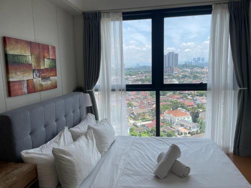 a bed with a teddy bear on it in front of a window at THE HUB SS2 in Petaling Jaya