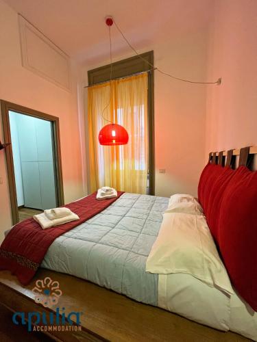 a bedroom with a large bed with a red lamp at Suite Nana by Apulia Accommodation in Bari