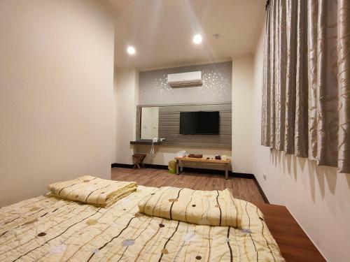 1 dormitorio con 1 cama grande y TV en Lai Yi Ke Homestay, en Baisha