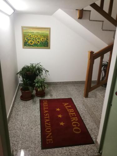 una alfombra de bienvenida en el suelo de una escalera con una pintura en ALBERGO DELLA STAZIONE, en Cairo Montenotte