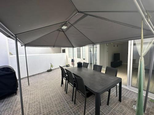 un tavolo nero e sedie sotto un ombrellone di Apartamento T2 com terraço a 100 metros da praia a Carvoeiro