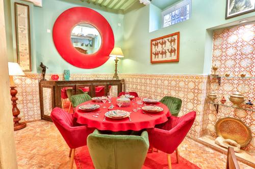 een eetkamer met een rode tafel en rode stoelen bij RYAD DES NOMADES in Essaouira