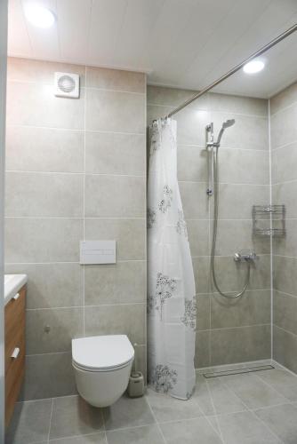 a bathroom with a shower with a toilet and a shower curtain at Apartment Secret in Jonava