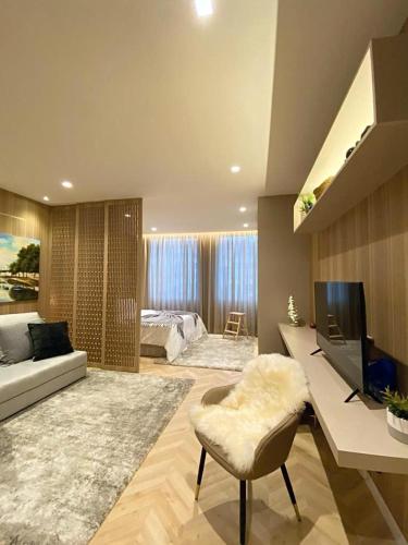 a large living room with a bed and a television at Alamedastudio in Vila do Conde