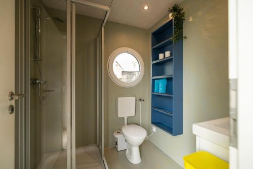 a bathroom with a toilet and a glass shower at Hafenresort Karnin _ Hausboot Selma in Karnin