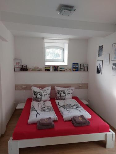 a bedroom with a red and white bed with a window at Ferienwohnung "Alte Mühle" in Jena