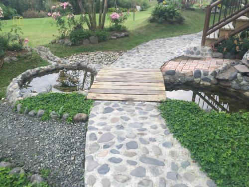 a wooden bridge over a pond in a garden at Matisses Hotel & Spa in Santa Rosa de Cabal