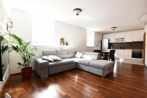 a living room with a couch and a kitchen at Apartments Kokolo in Šibenik