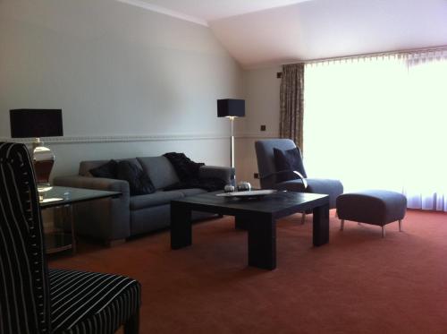 a living room with a couch and a table at Hotel Scherf in Bad Lippspringe