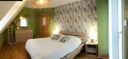 La Rivière Saint SauveurにあるLe Jardin de Venusの緑の壁のベッドルーム1室(白いベッド1台付)