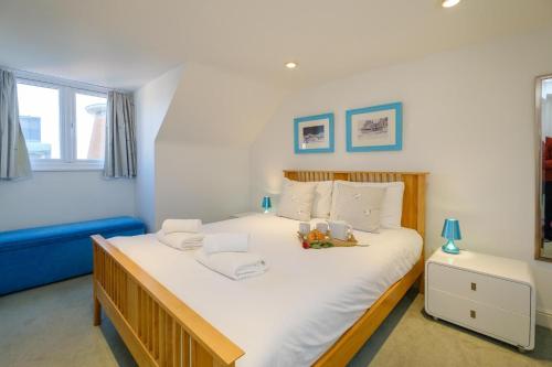 a bedroom with a large white bed and a blue couch at Admiral's Rest in Aldeburgh