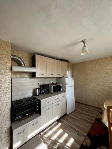 una cucina con piano cottura e frigorifero di Апартамент във вила Артемида a Varna
