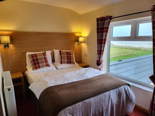 a bedroom with a bed and a large window at The Cliff Top Inn in Bacton