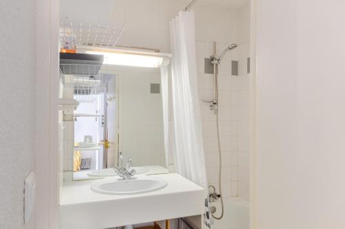 uma casa de banho com um lavatório e um chuveiro em La Baregine em Barèges