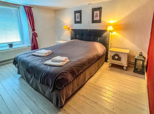 een slaapkamer met een bed met twee handdoeken erop bij La Maison Hôte, gîte de charme en bord de Semois in Bouillon